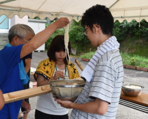 地域の方とそうめんを流す金大生